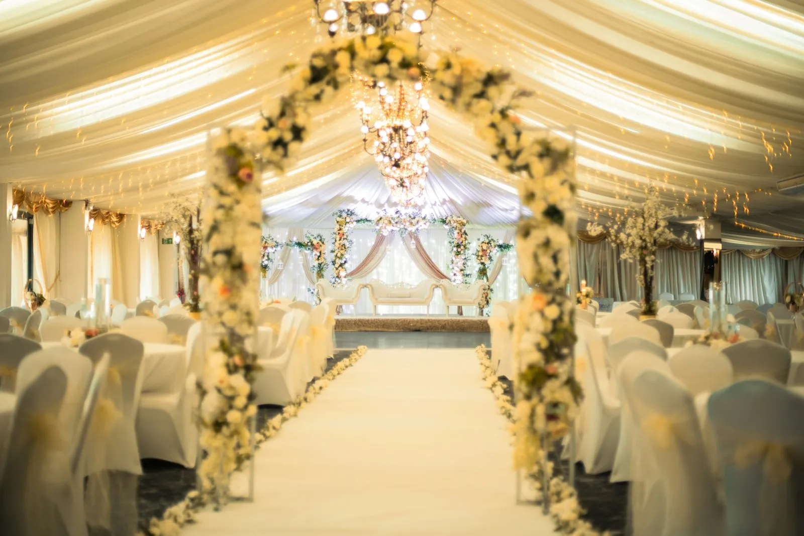 Tented aisle with a floral arch