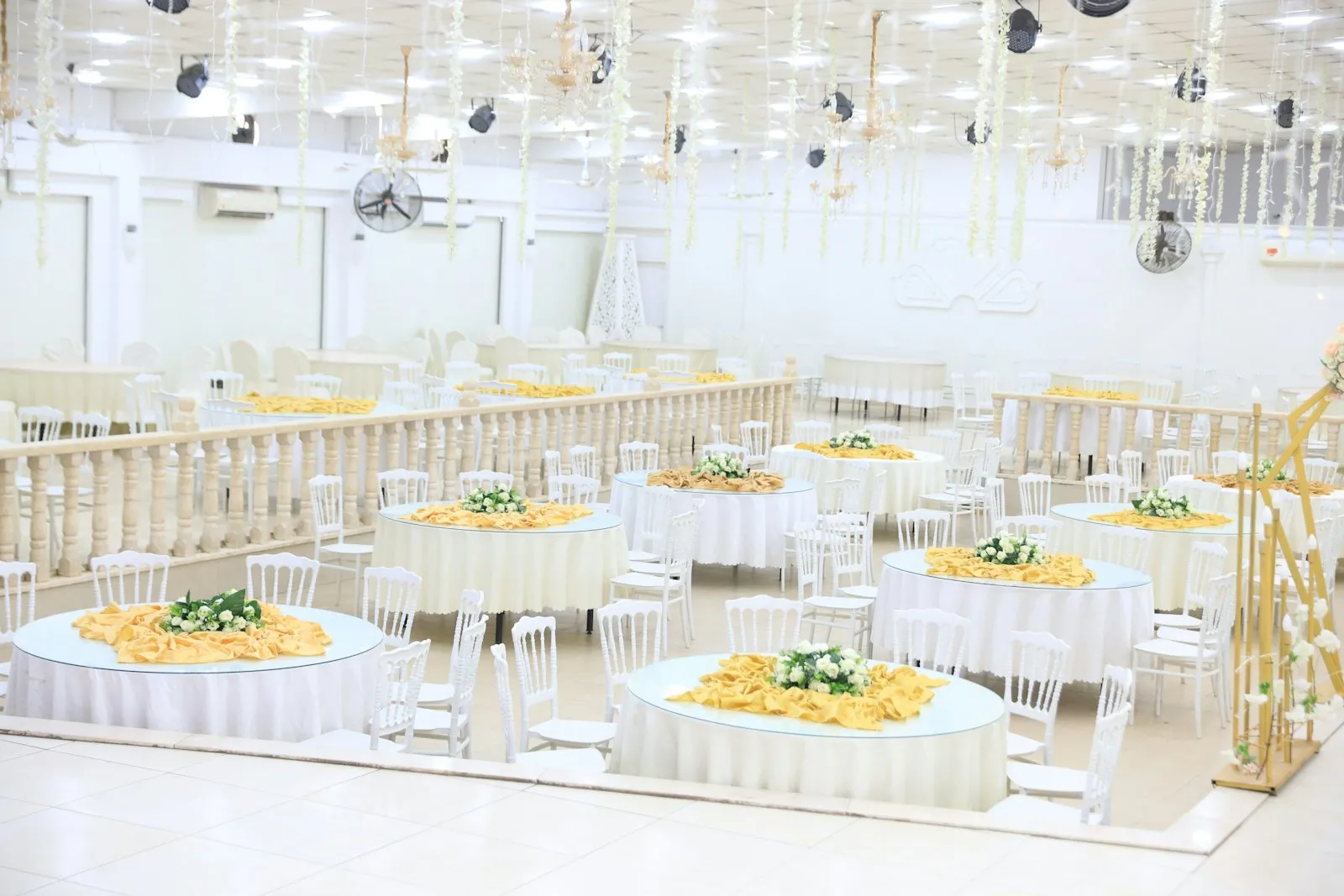 A bright hall mid-setup with round tables